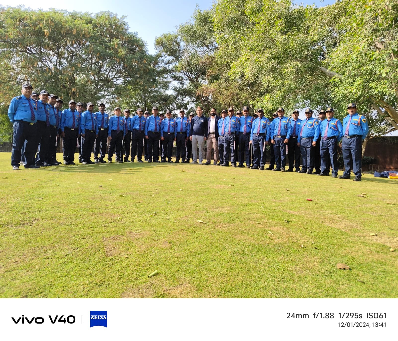Security team lineup on lawn with management